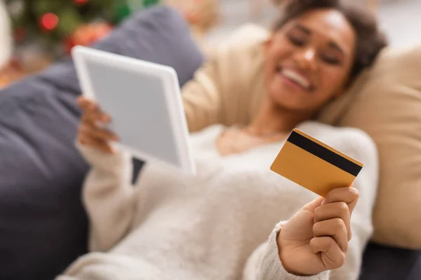 Размытая африканская американка держит дома цифровой планшет и кредитную карту — стоковое фото