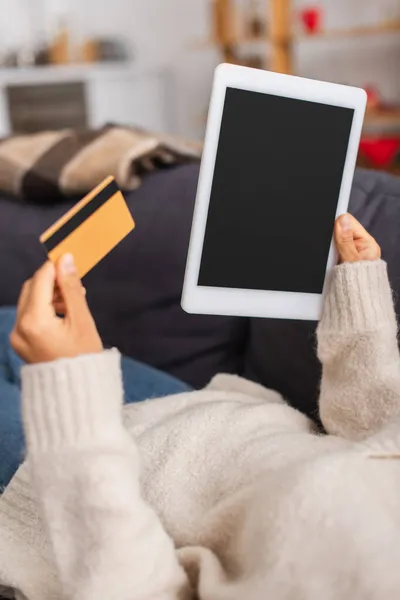 Обрізаний вид афроамериканки, що тримає цифровий планшет з порожнім екраном і кредитною карткою на дивані — стокове фото