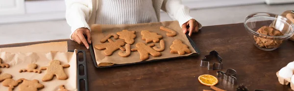 Vista cortada da mulher americana africana segurando bandeja com pães de gengibre de Natal, banner — Fotografia de Stock