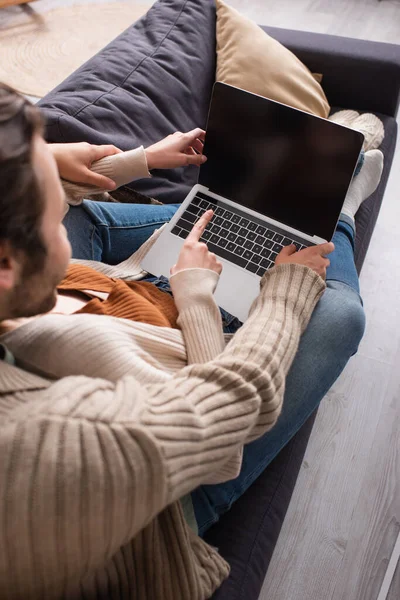 Overhead view of woman pointing at laptop with blank screen near husband — Stock Photo