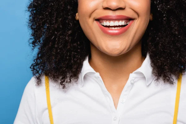 Vista de cerca de la mujer afroamericana recortada sonriendo aislado en azul - foto de stock