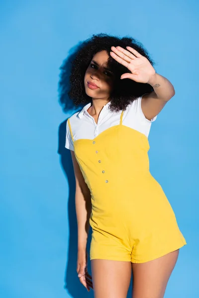 Displeased african american woman showing stop gesture at camera on blue — Stock Photo