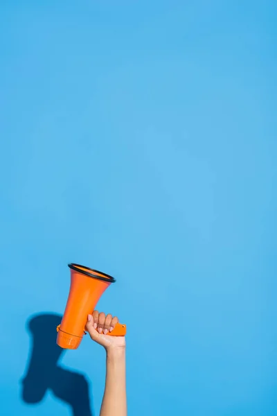 Vue partielle de la femme afro-américaine avec mégaphone orange sur bleu — Photo de stock