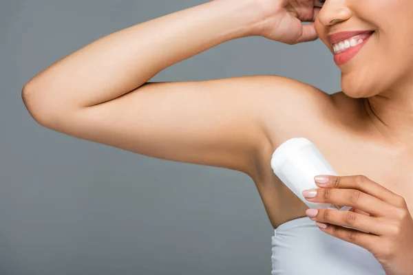 Cropped view of african american woman applying dry deodorant on armpit isolated on grey — Stock Photo