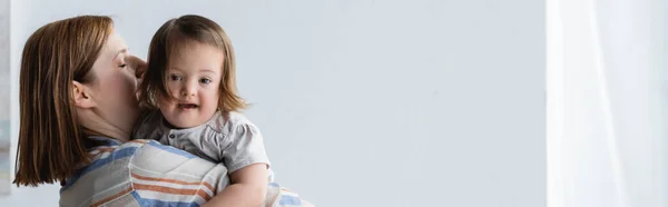 Woman holding toddler daughter with down syndrome at home, banner — Stock Photo