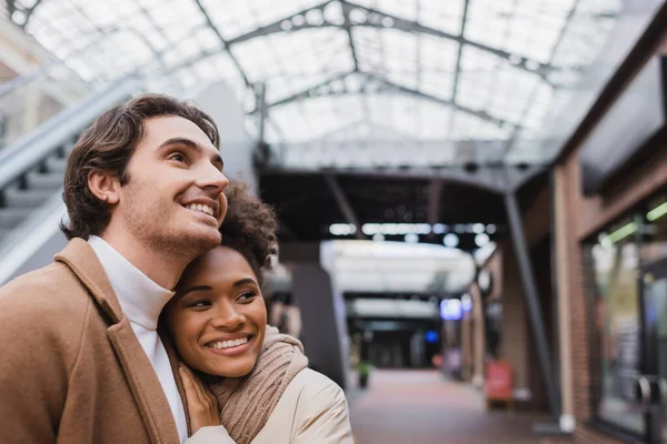 Heureux interracial couple sourire dans centre commercial — Photo de stock