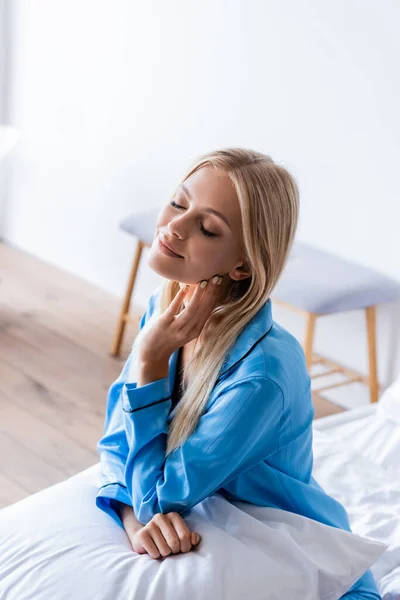 High angle view of joyful young woman sitting on bed — Stock Photo