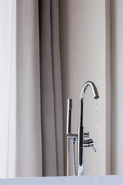 Water running from faucet in modern bathroom — Stock Photo