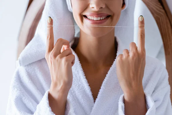 Partial view of happy woman holding dental floss in bathroom — Stock Photo