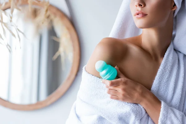 Обрізаний вид молодої жінки, що тримає дезодорант у ванній кімнаті — стокове фото
