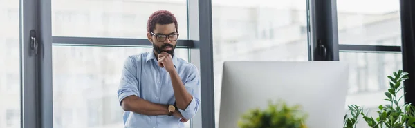 Fokussierter afrikanisch-amerikanischer Geschäftsmann blickt auf Computermonitor im Büro, Banner — Stockfoto