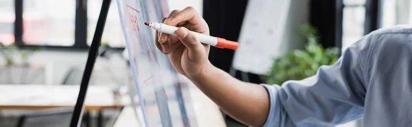 Vista recortada del gerente afroamericano escribiendo en tablero de vidrio en la oficina, pancarta — Stock Photo