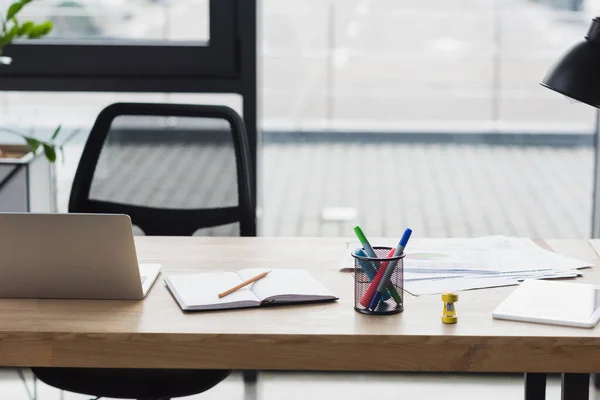 Devices and notebook on table in office — Stock Photo