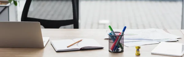 Dispositivos cerca del cuaderno y papeles en la mesa en la oficina, pancarta - foto de stock