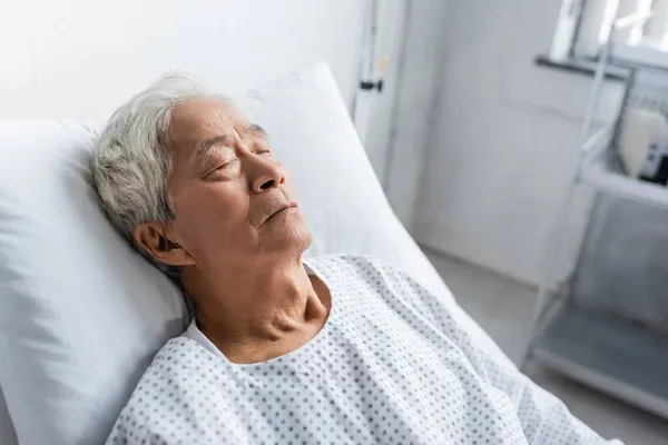 Sênior asiático paciente dormindo na cama no hospital ward — Fotografia de Stock