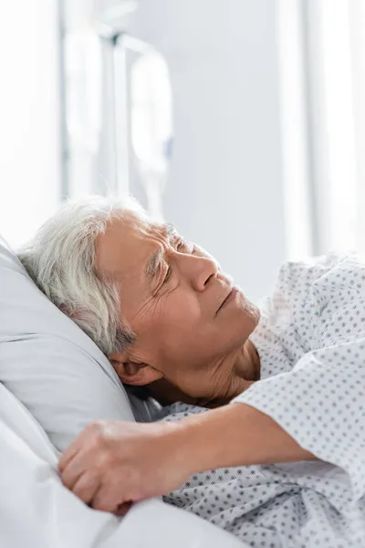 Enfermo asiático paciente acostado en cama en hospital sala - foto de stock