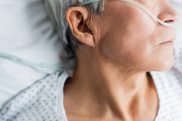 Vista ritagliata del paziente anziano con cannula nasale sdraiato sul letto in ospedale — Foto stock