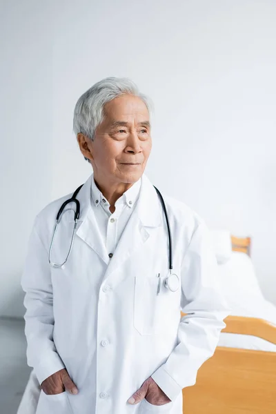 Asian doctor looking away in hospital ward — Stock Photo