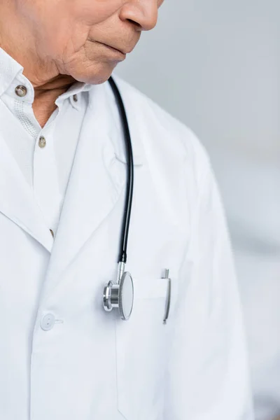 Cropped view of senior doctor with stethoscope standing in clinic — Stock Photo