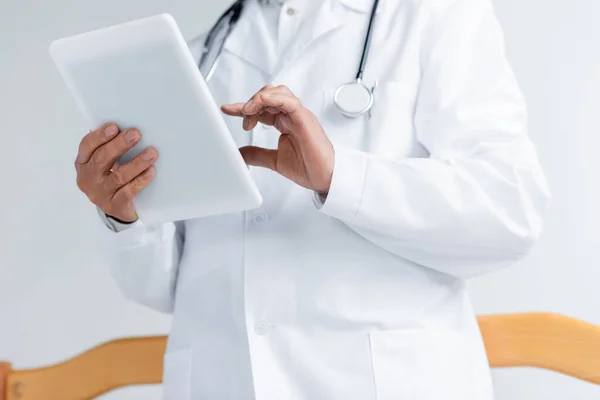 Cropped view of doctor in white coat using digital tablet in clinic — Stock Photo