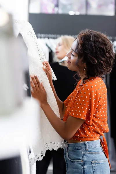 Freudige afrikanisch-amerikanische Frau wählt Kleidung in Boutique — Stockfoto