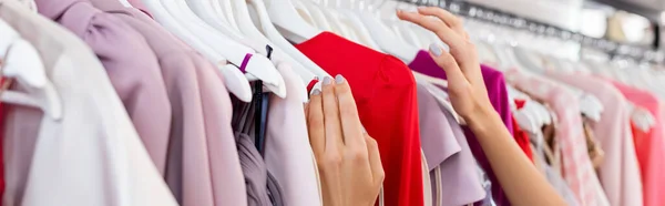 Visão parcial da mulher escolhendo roupas em boutique, banner — Fotografia de Stock