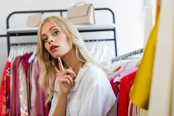 Chère femme blonde regardant loin dans la boutique — Photo de stock