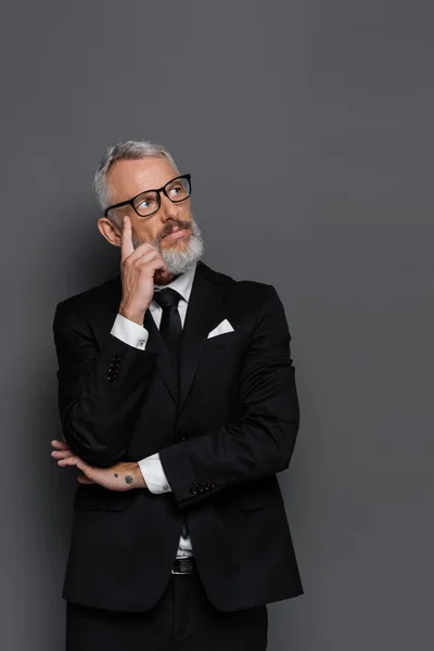 Cher homme d'affaires d'âge moyen dans des lunettes regardant loin isolé sur gris — Photo de stock