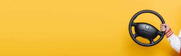 Cropped view of middle aged man holding steering wheel and showing like on yellow, banner — Stock Photo