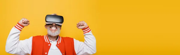 Mann mittleren Alters in Bomberjacke und Vr-Headset jubelt isoliert auf gelb, Banner — Stockfoto