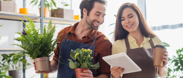 Florists working with digital tablet and plants in flower shop, banner — Stock Photo
