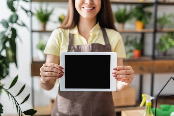 Vista recortada de la tableta digital en manos de florista sonriente en la tienda - foto de stock