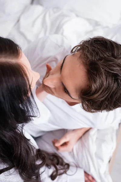 Top view of brunette woman near young man in bedroom — Stock Photo