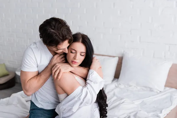 Sensual morena mulher com olhos fechados perto jovem homem seduzindo-a no quarto — Fotografia de Stock