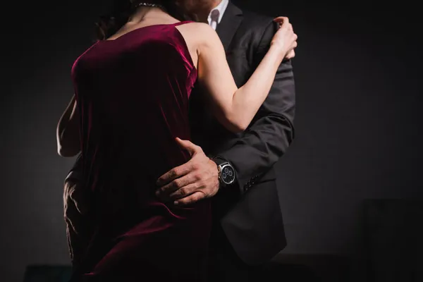 Partial view of man in suit embracing hips of elegant woman at night — Stock Photo
