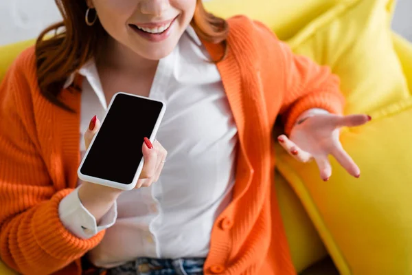 Vue recadrée de la femme souriante gestuelle tout en envoyant un message vocal sur un téléphone mobile avec écran blanc — Photo de stock