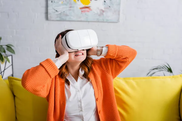 Angespannte Frau berührt Kopf beim Spielen in vr Headset zu Hause — Stockfoto