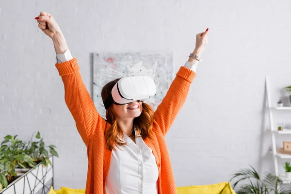 Excited woman showing yeah gesture while gaming in vr headset at home — Stock Photo