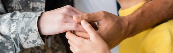 Vista ritagliata della famiglia e della mamma in uniforme militare che si tiene per mano, banner — Foto stock