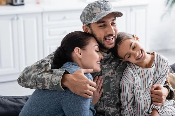 Freudiger Mann in Militäruniform umarmt Tochter und Ehefrau zu Hause — Stockfoto