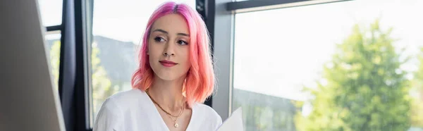 Mujer de negocios perforada con cabello rosa mirando el monitor de la computadora, pancarta - foto de stock