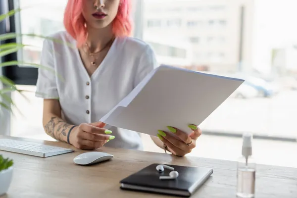 Cropped view of pierced businesswoman with pink hair holding folder in office — Stock Photo