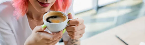 Cropped view of pierced manager with pink hair holding cup of coffee in office, banner — Stock Photo