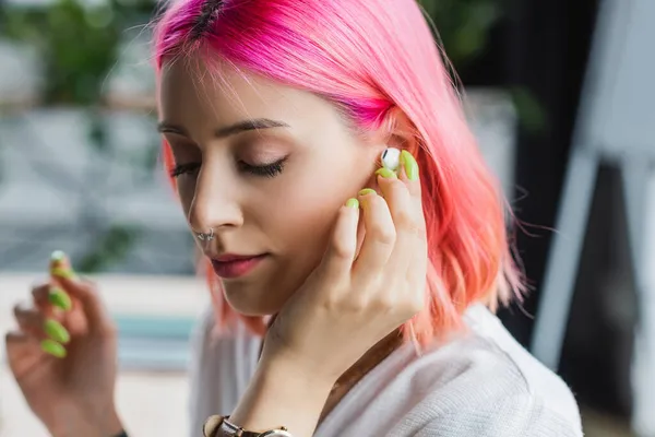 Mujer de negocios perforada con el pelo rosa auricular de ajuste - foto de stock