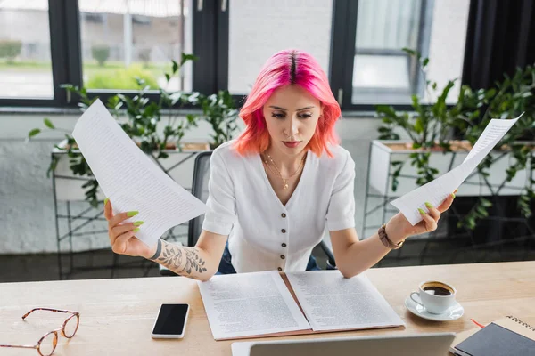 Mujer de negocios ocupada con coloridos documentos de cabello cerca de dispositivos en el escritorio - foto de stock