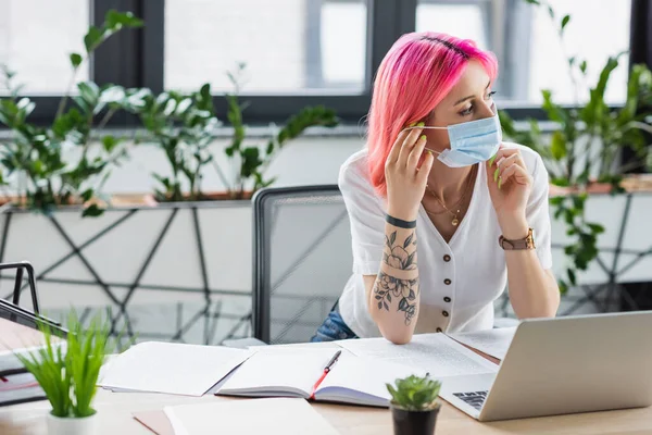 Manager mit pinkfarbenen Haaren trägt Arztmaske im Büro — Stockfoto