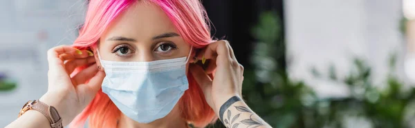 Tattooed young manager with pink hair wearing medical mask in office, banner — Stock Photo