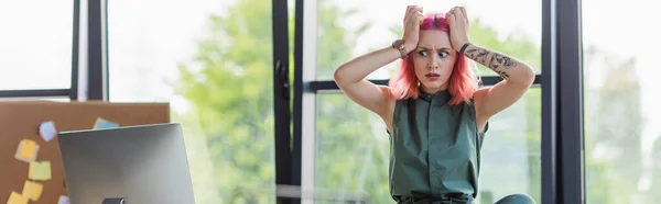 Mulher de negócios estressada com cabelo rosa olhando para monitor de computador no escritório, banner — Fotografia de Stock