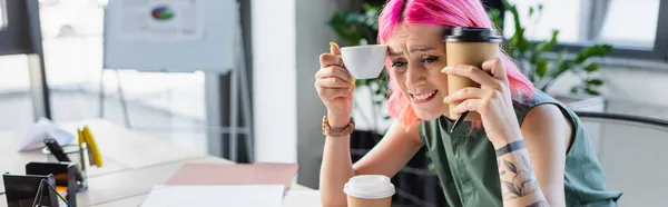 Femme d'affaires inquiète avec les cheveux roses tenant café dans le bureau, bannière — Photo de stock