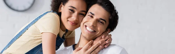 Sorridente donna afroamericana che abbraccia il fidanzato a casa, striscione — Foto stock